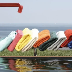 Frottier Auflage 190 x 70 cm für Amigo Liegen in verschiedenen Farben, auf einer roten Liege über Wasser arrangiert.