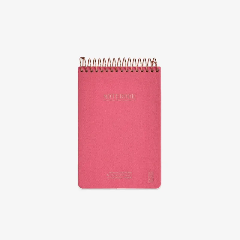Pink notebook with gold spiral binding on a white background